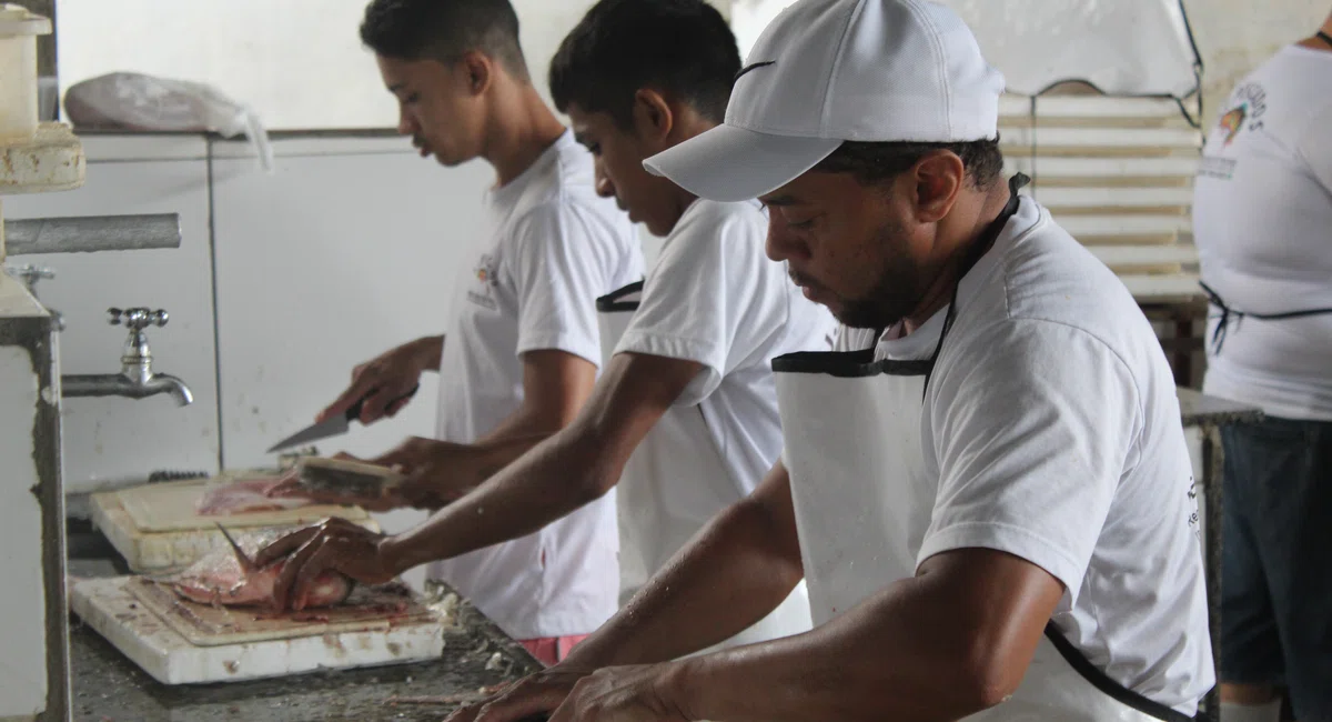 Homens tratando peixes