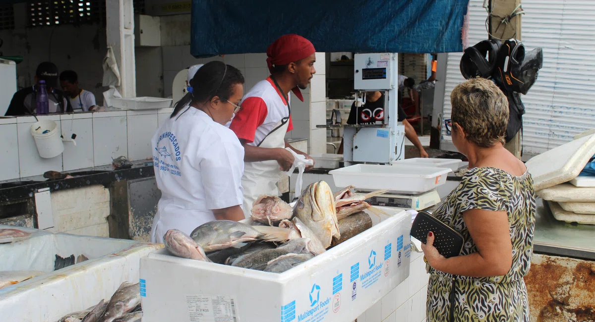 Mulher comprando peixe no Mercado