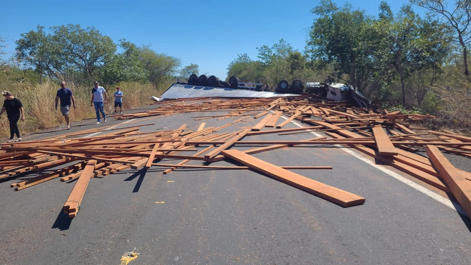 Caminhão e carga espalhada pela via.