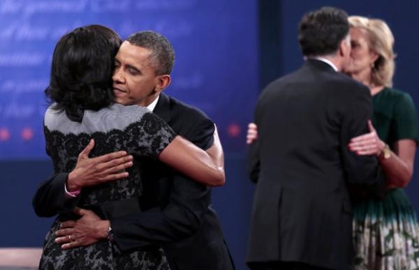 Após o debate, Obama abraça Michelle, e Romney abraça Ann(Imagem:AFP) Após o debate, Obama abraça Michelle, e Romney abraça Ann(Imagem:AFP)