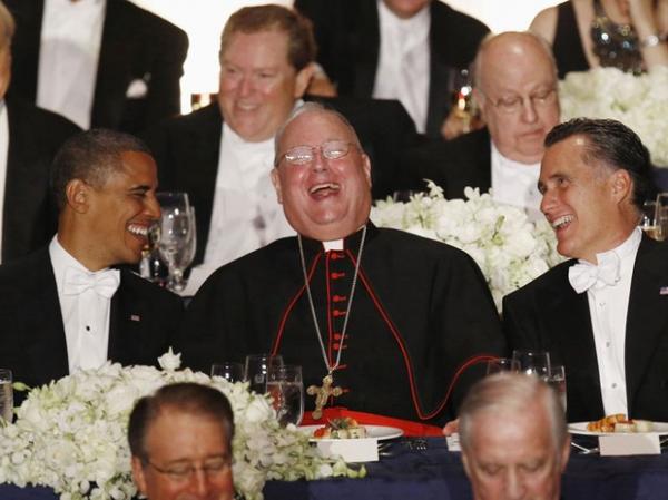 O presidente Barack Obama (esq.) e seu adversário na eleição presidencial dos EUA, Mitt Romney (dir.) riem com o cardeal Timothy Dolan durante evento de caridade realizado na véspe(Imagem:Reprodução) O presidente Barack Obama (esq.) e seu adversário na eleição presidencial dos EUA, Mitt Romney (dir.) riem com o cardeal Timothy Dolan durante evento de caridade realizado na véspe(Imagem:Reprodução)